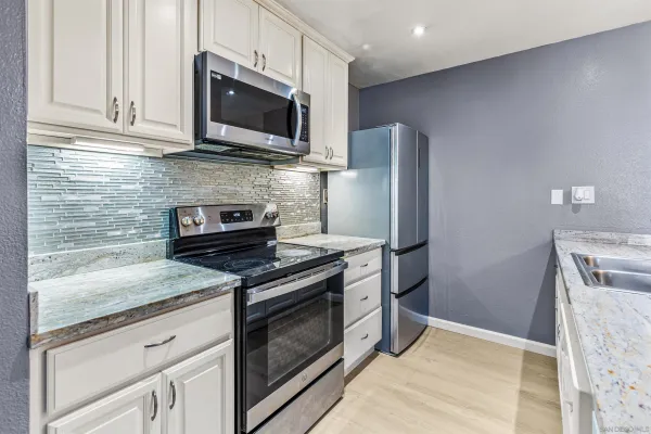 a kitchen with stainless steel appliances granite countertop a stove microwave and refrigerator