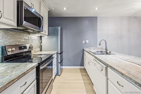 a kitchen with stainless steel appliances granite countertop a sink stove and microwave
