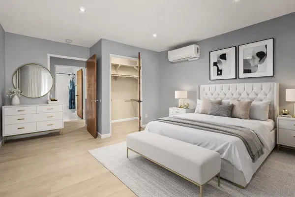 a spacious bedroom with a bed a mirror and a dresser