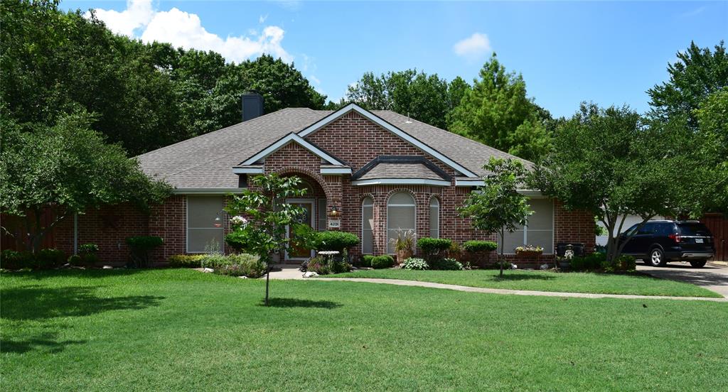 4201 Glistening Spring Rowlett, TX 75088 - Photo 3 of 33 Traditional brick residence featuring a prominent arched entry, a gabled roofline, and a bay window