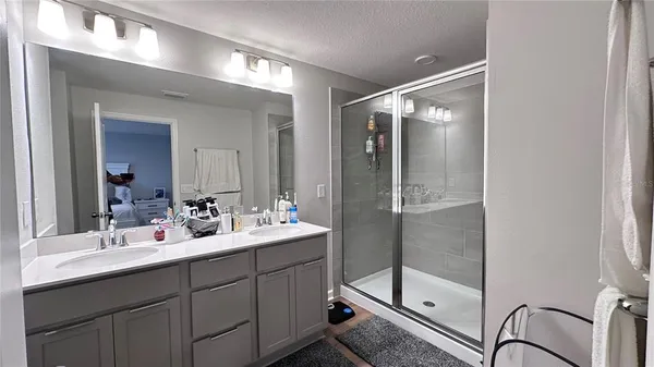 a bathroom with a shower sink and mirror