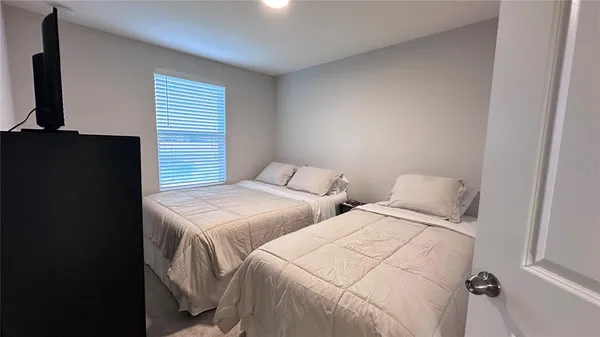a bedroom with two beds and a flat screen tv