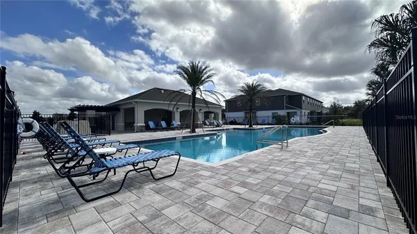 a view of house with swimming pool and sitting area