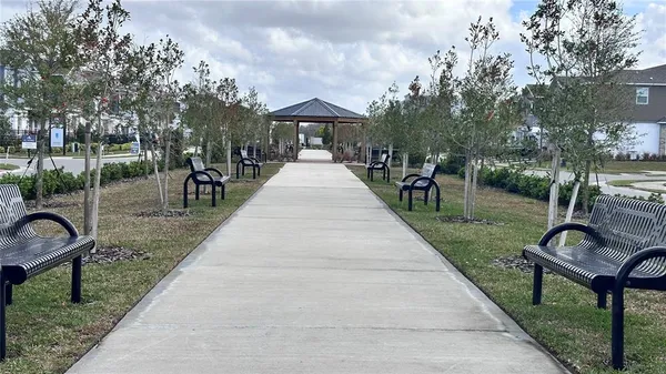 a view of a park with furniture and garden