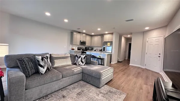 a living room with furniture and kitchen view