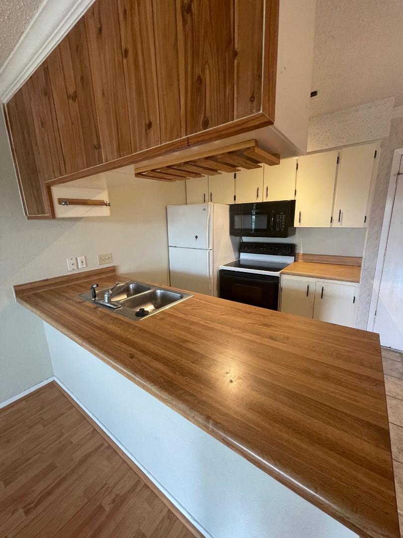 910 Duncan Lane, Unit 44 Austin, TX 78705 - Photo 5 of 15 A functional kitchen boasts light wood countertops and a convenient double-basin sink.