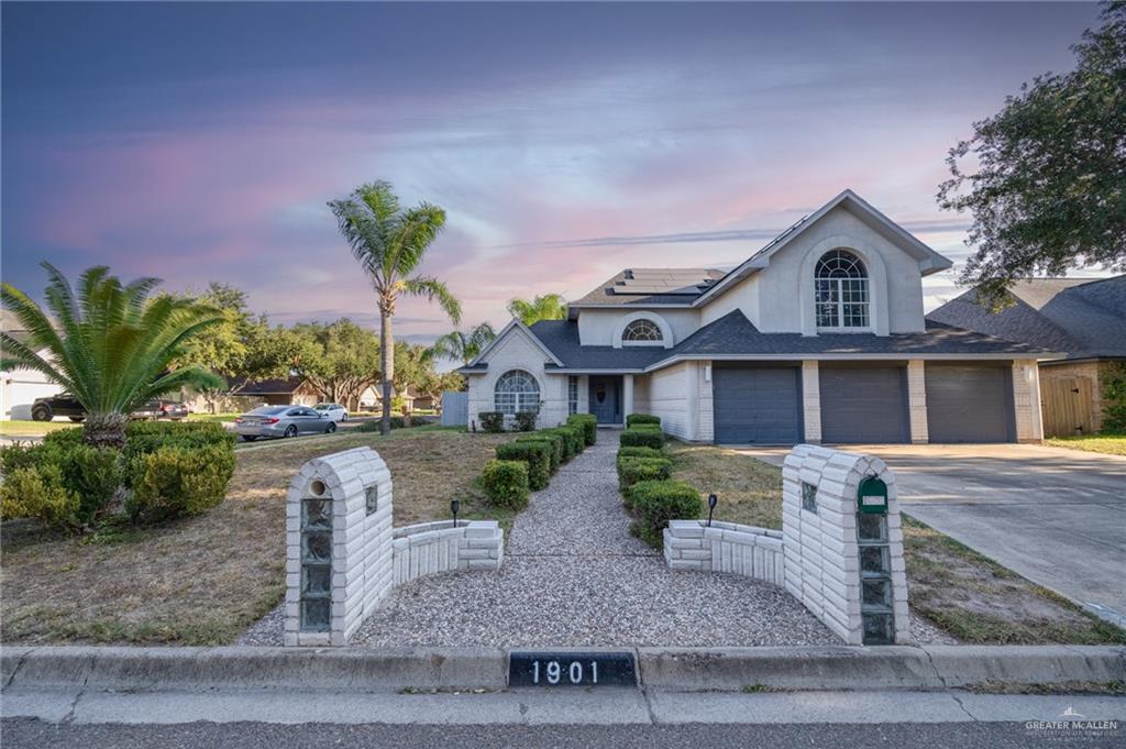 View of front property featuring a garage and solar panels