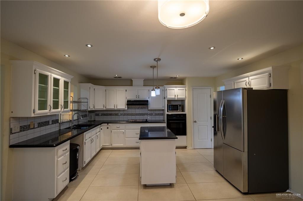 1901 Duke Avenue McAllen, TX 78504 - Photo 13 of 44 Kitchen featuring white cabinetry, decorative light fixtures, black appliances, and a kitchen island