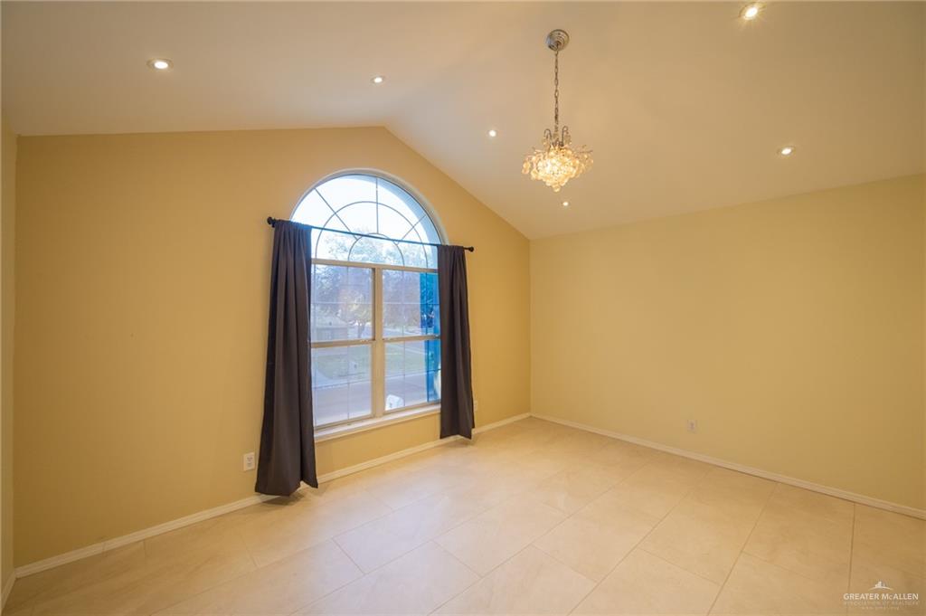 1901 Duke Avenue McAllen, TX 78504 - Photo 33 of 44 Empty room featuring light tile patterned flooring, lofted ceiling, and an inviting chandelier