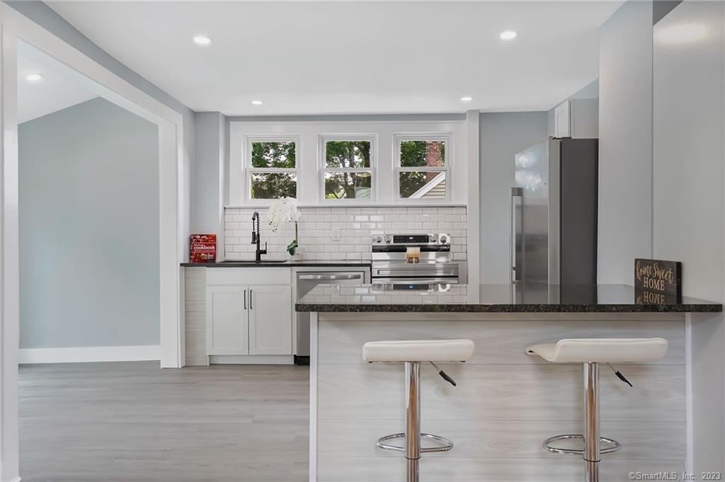 a kitchen with stainless steel appliances granite countertop a sink and cabinets