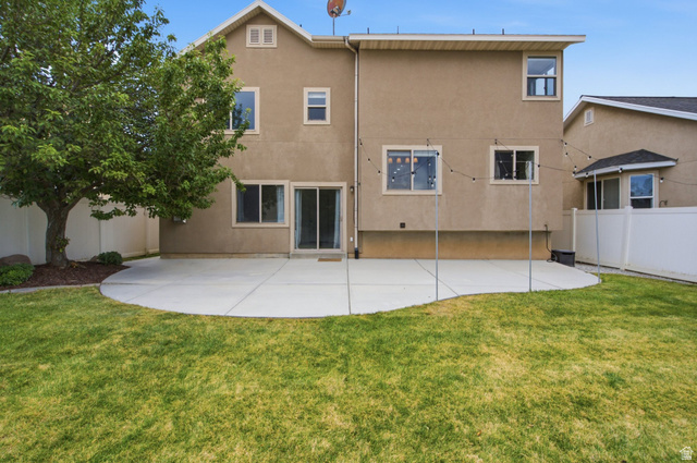 2223 North Pointe Meadow Loop Lehi, UT 84048 - Photo 45 of 56 Expansive rear yard featuring a manicured lawn, a large curved concrete patio, and mature tree