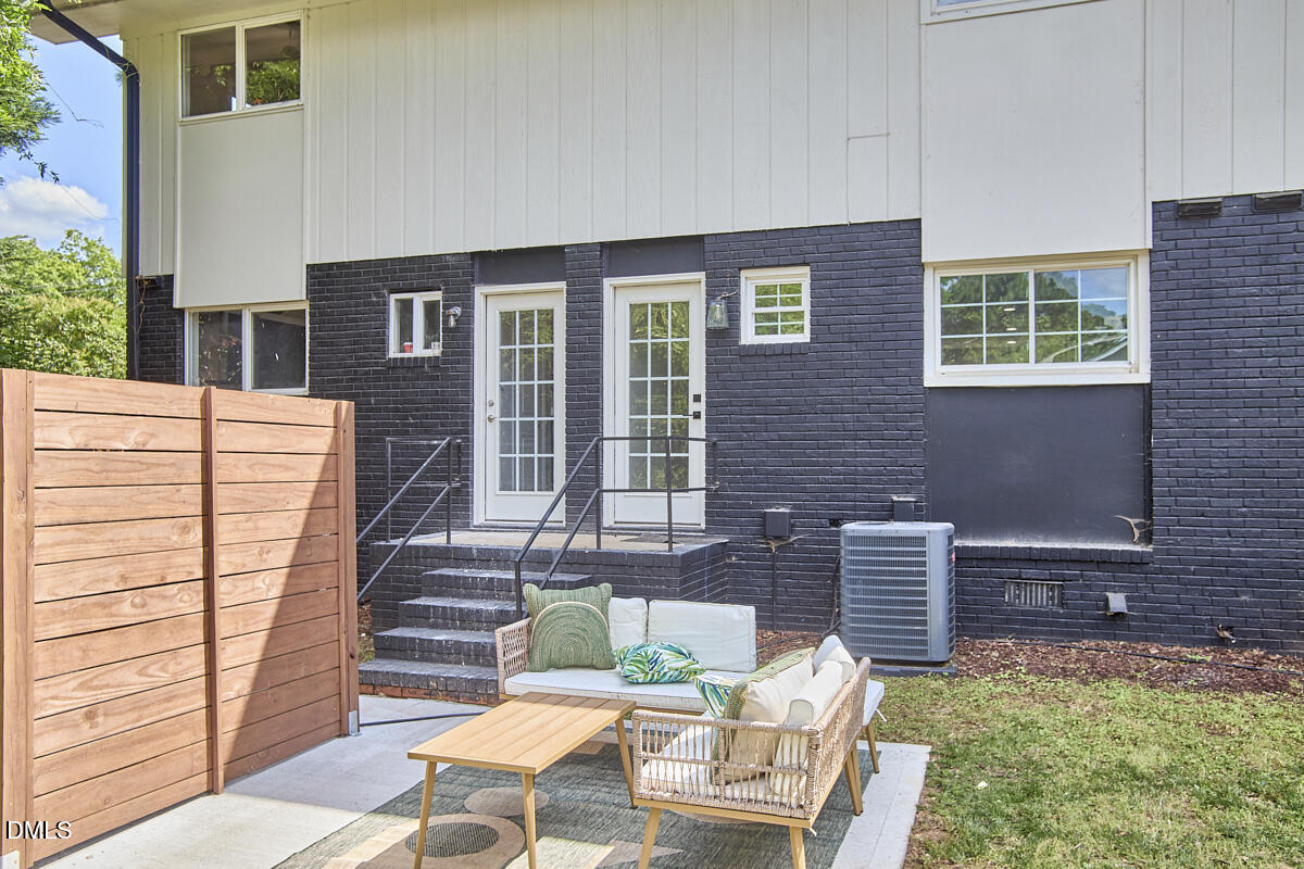 2613 McNeil Street, Unit E Raleigh, NC 27608 - Photo 27 of 28 a view of a patio with table and chairs with wooden fence
