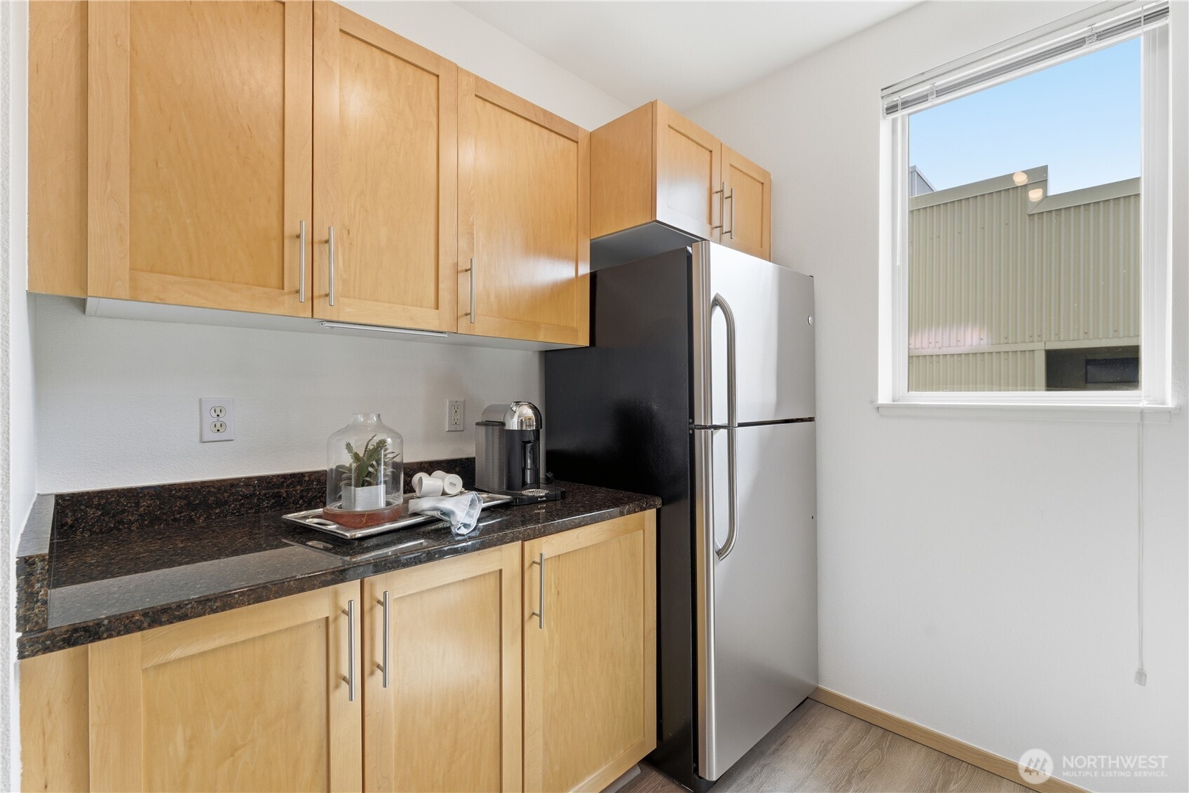 3333 Wallingford Avenue North, Unit 203 Seattle, WA 98103 - Photo 18 of 37 a kitchen with a refrigerator and cabinets