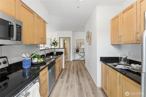 a kitchen with stainless steel appliances granite countertop a stove a sink and a microwave