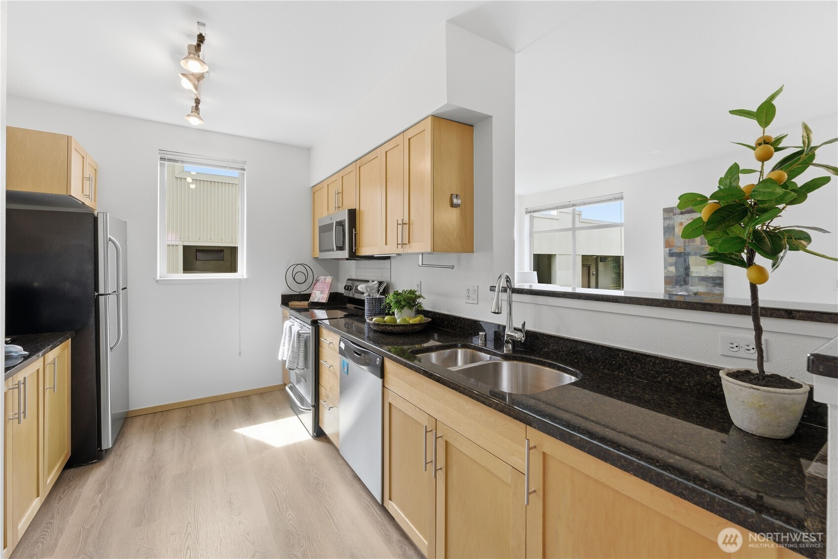 3333 Wallingford Avenue North, Unit 203 Seattle, WA 98103 - Photo 20 of 37 a kitchen with stainless steel appliances a sink a stove and a wooden floor
