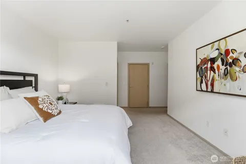 a bedroom with a bed and painting on the wall