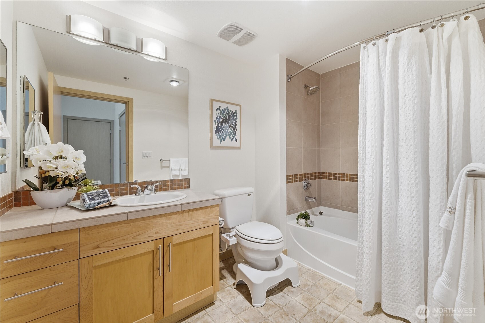 3333 Wallingford Avenue North, Unit 203 Seattle, WA 98103 - Photo 25 of 37 a spacious bathroom with a granite countertop sink toilet mirror and a bathtub