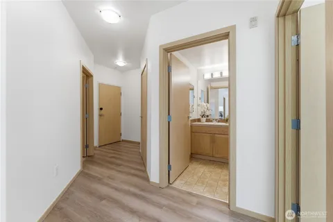 a view of a hallway with a dining room with wooden floor