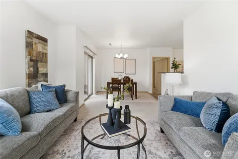 a living room with furniture and a view of kitchen