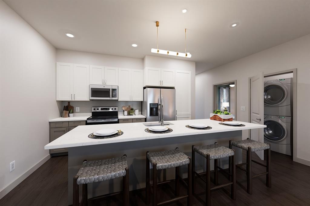 10715 Garland Road, Unit 5001 Dallas, TX 75218 - Photo 5 of 11 a kitchen with stainless steel appliances kitchen island granite countertop a table chairs stove and white cabinets