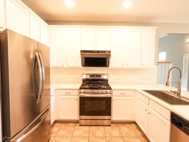 a kitchen with a refrigerator and a stove top oven