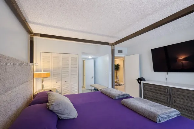 a bedroom with a bed and a flat screen tv