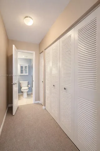 a view of a livingroom with wooden floor and a bathroom