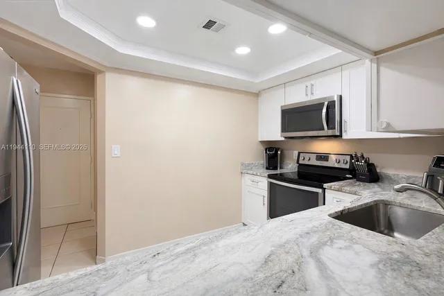 a kitchen with granite countertop a refrigerator stove and microwave