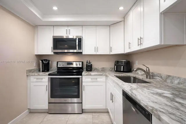 a kitchen with granite countertop a stove sink and cabinets
