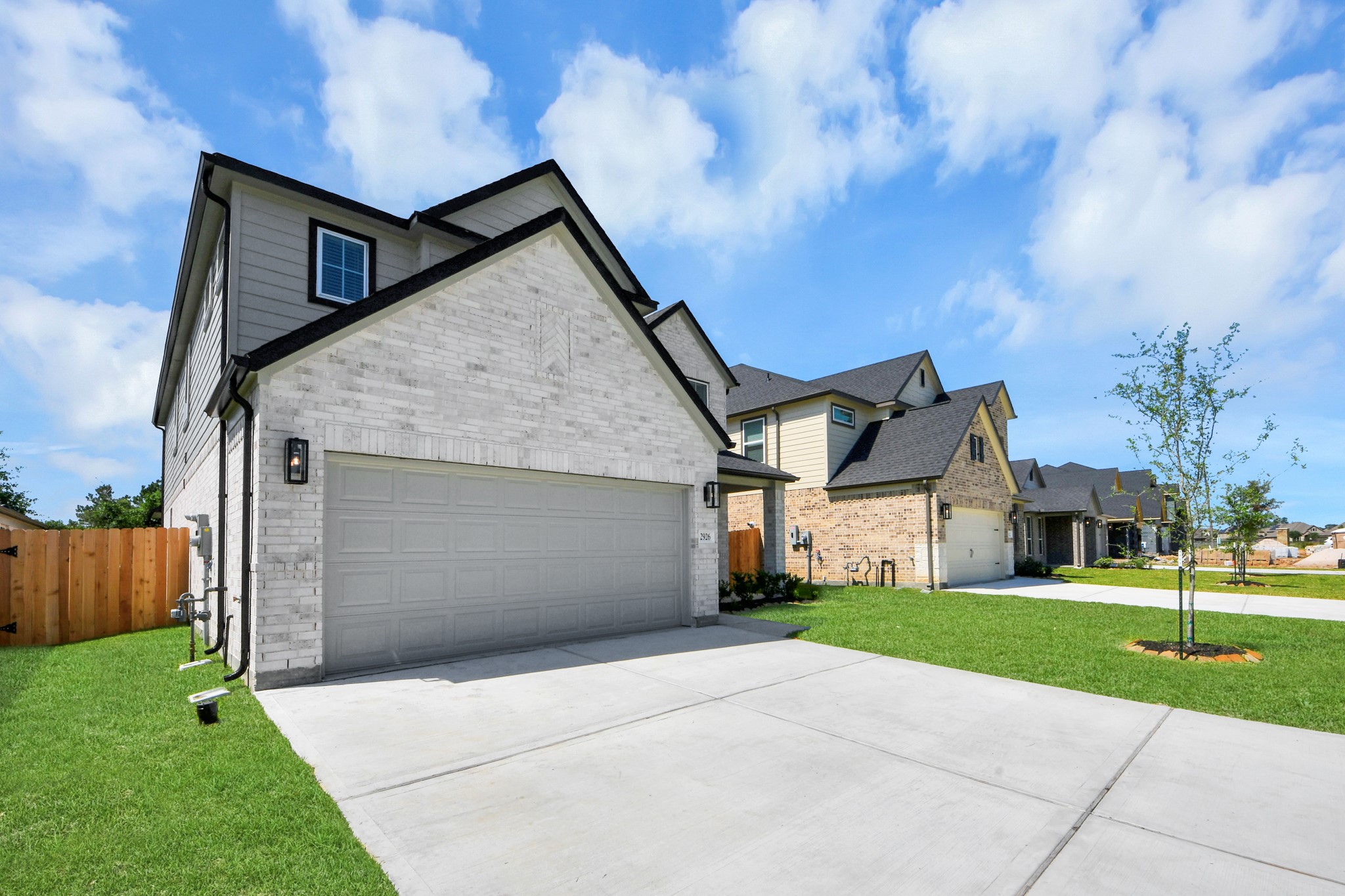 2926 Bury Park Dr Spring Spring, TX 77373 - Photo 2 of 40 The residence features a practical 2-car garage complemented by a generous driveway, ensuring abundant space for parking needs.
