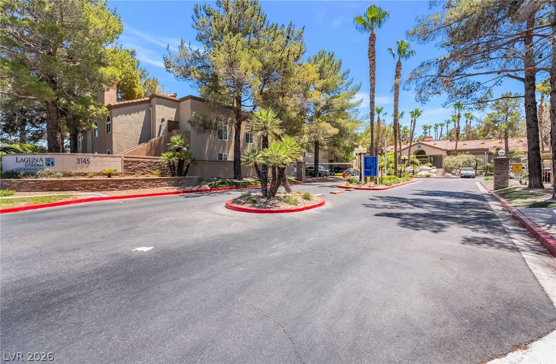 3145 East Flamingo Road, Unit 1092 Las Vegas, NV 89121 - Photo 24 of 33 A welcoming entry with lush landscaping and towering trees sets a serene tone.