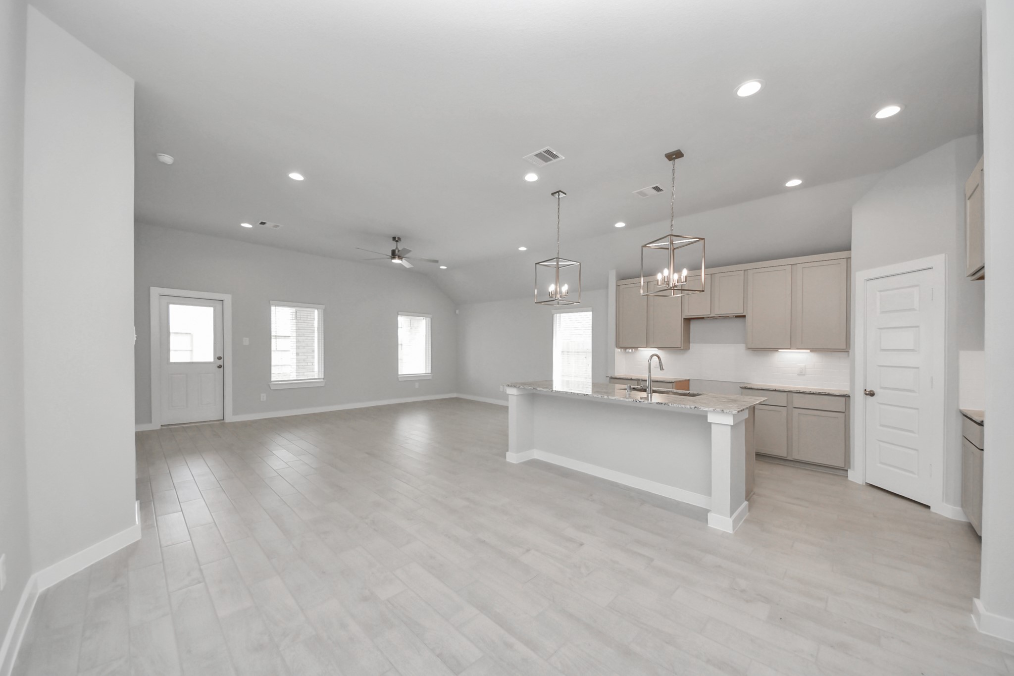 24518 Broad Park Spring, TX 77373 - Photo 20 of 29 Relax and unwind in this inviting family room, illuminated by abundant natural light streaming in through tall windows, complemented by high ceilings and stunning flooring. Stay comfortable year-round with the gentle breeze from the ceiling fan, creating the perfect atmosphere for family gatherings. Sample photo of completed home with similar floor plan. Actual colors and selections may vary.