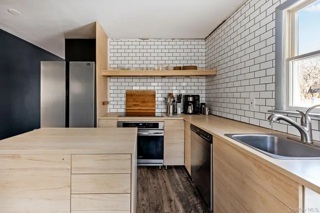 a kitchen with a sink a counter top space and stainless steel appliances