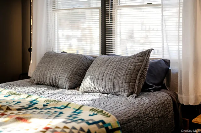 a bedroom with a bed and a dresser with closet