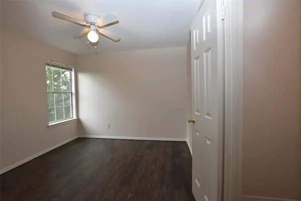 an empty room with wooden floor and window