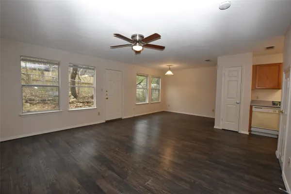 a view of an empty room with window and wooden floor