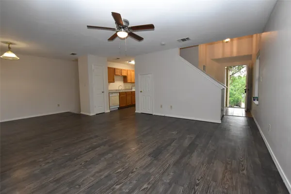 a view of a livingroom with wooden floor and a ceiling fan
