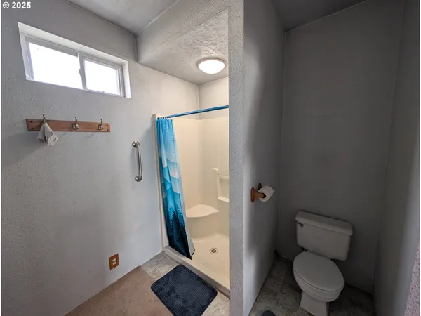 a bathroom with a toilet and a shower