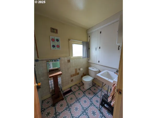 a bathroom with a toilet a sink and mirror