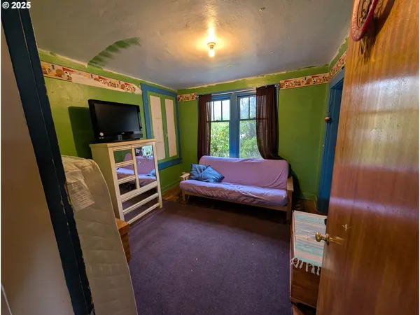 a bedroom with furniture and a flat screen tv