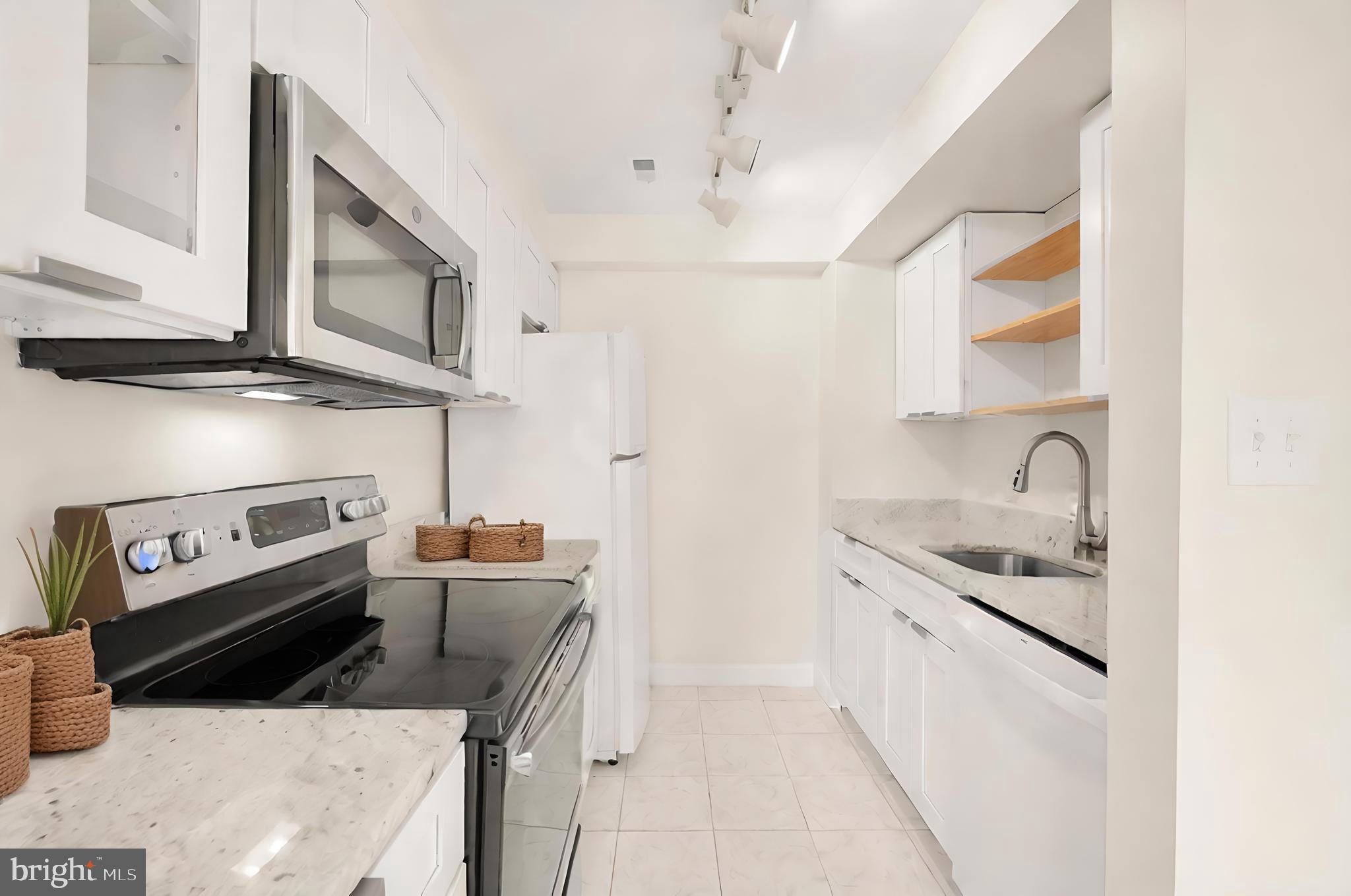 2114 N Street Northwest, Unit 47 Washington, DC 20037 - Photo 11 of 28 a kitchen with stainless steel appliances granite countertop a sink and a stove