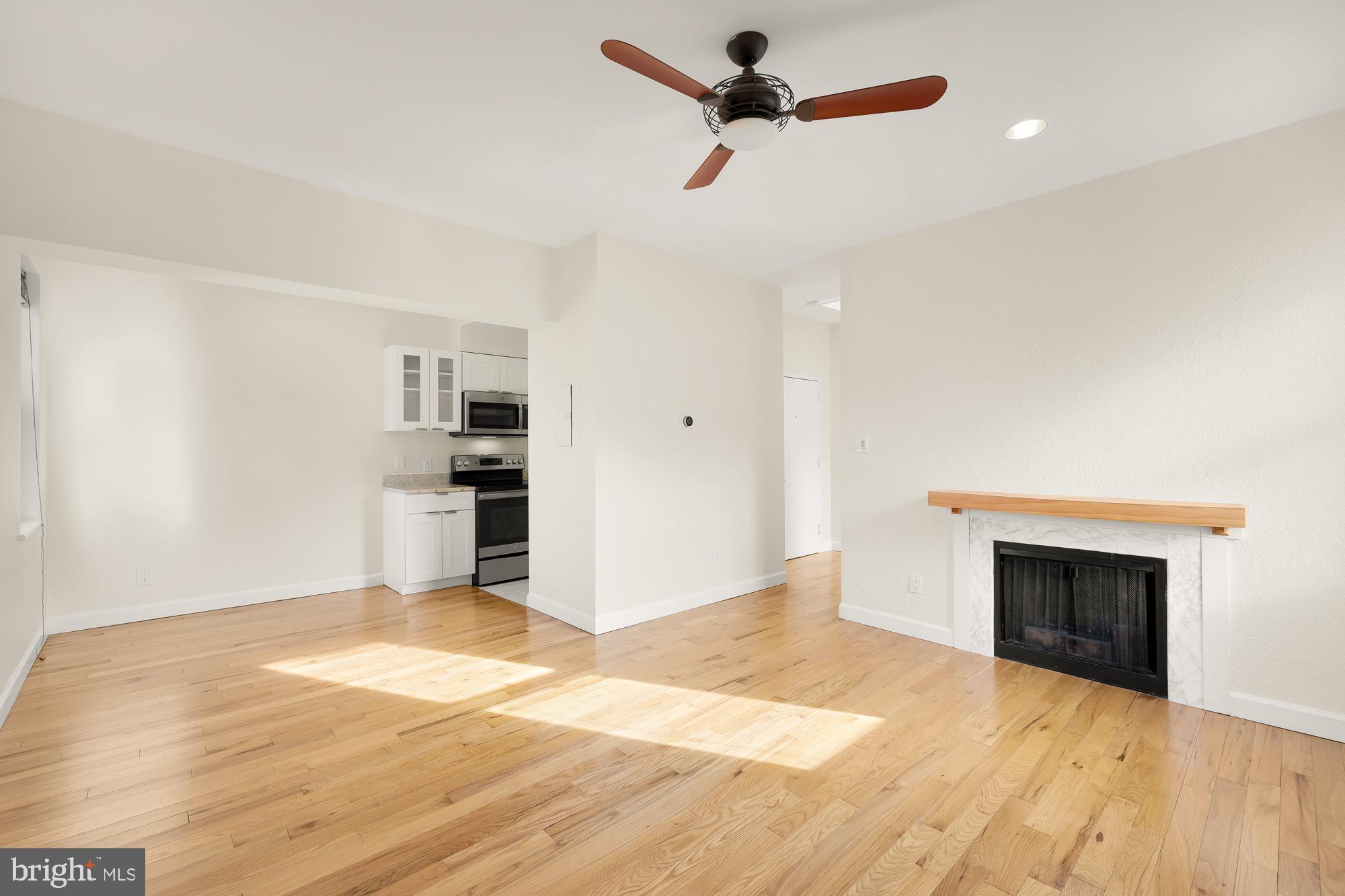 2114 N Street Northwest, Unit 47 Washington, DC 20037 - Photo 9 of 28 a view of empty room with wooden floor and fireplace