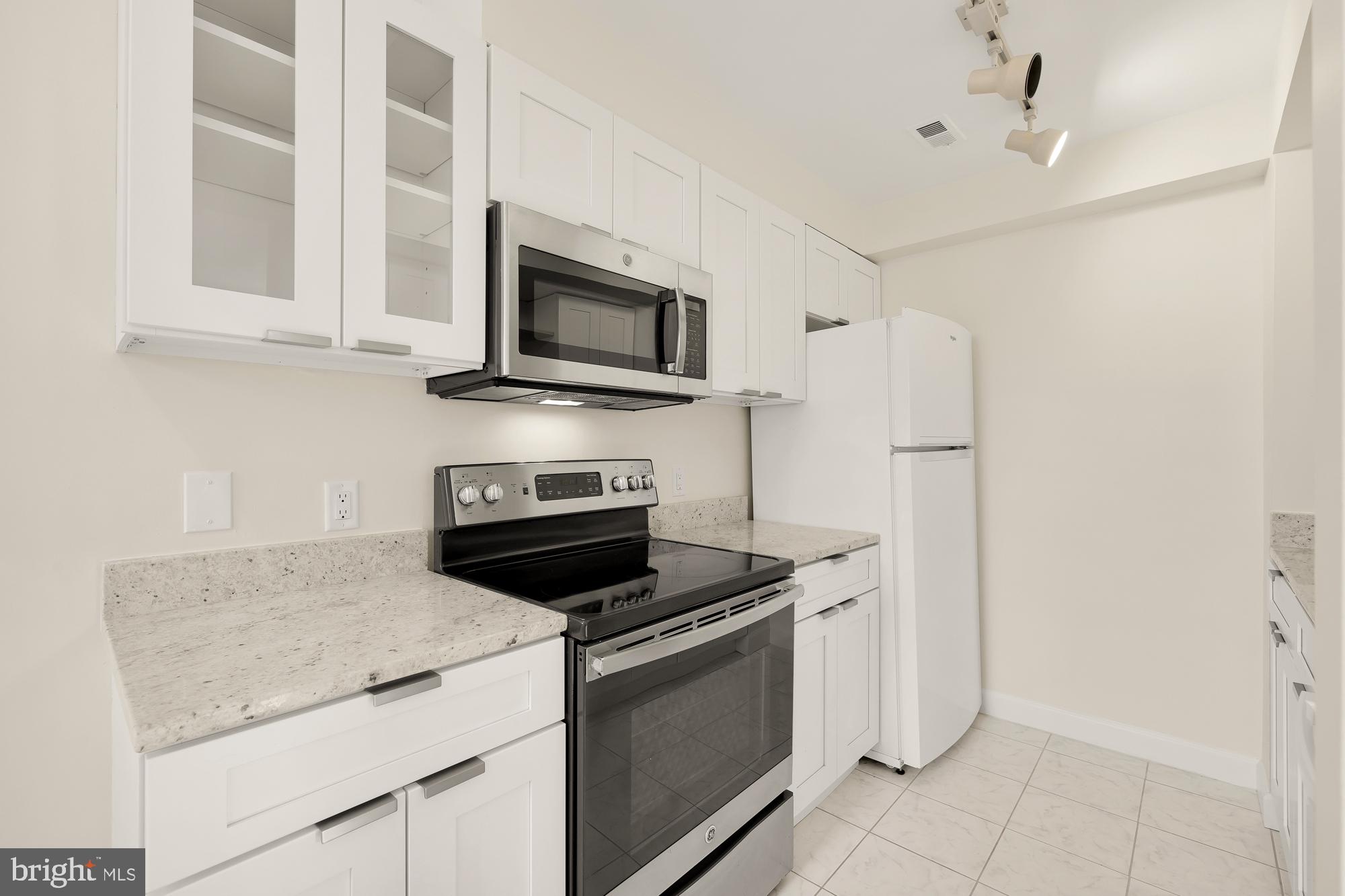 2114 N Street Northwest, Unit 47 Washington, DC 20037 - Photo 10 of 28 a kitchen with stainless steel appliances granite countertop white cabinets and a stove