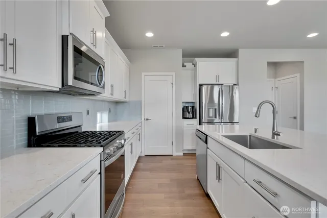 a kitchen with stainless steel appliances granite countertop a sink and a stove top oven