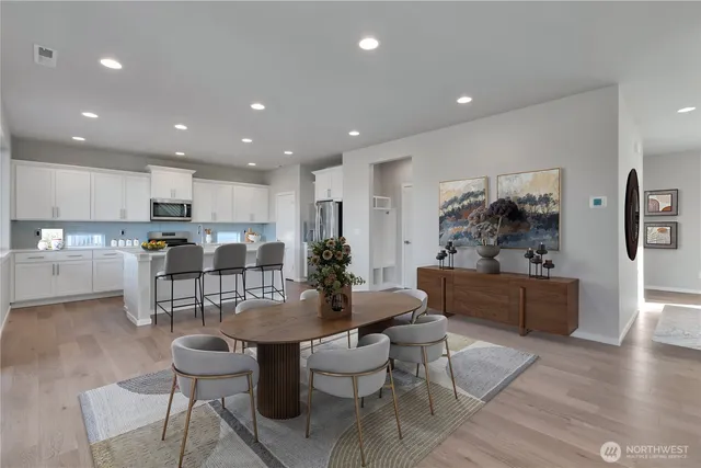 a living room with furniture and kitchen view with wooden floor