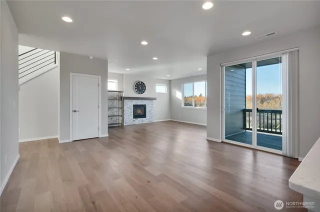 an empty room with wooden floor and a fireplace