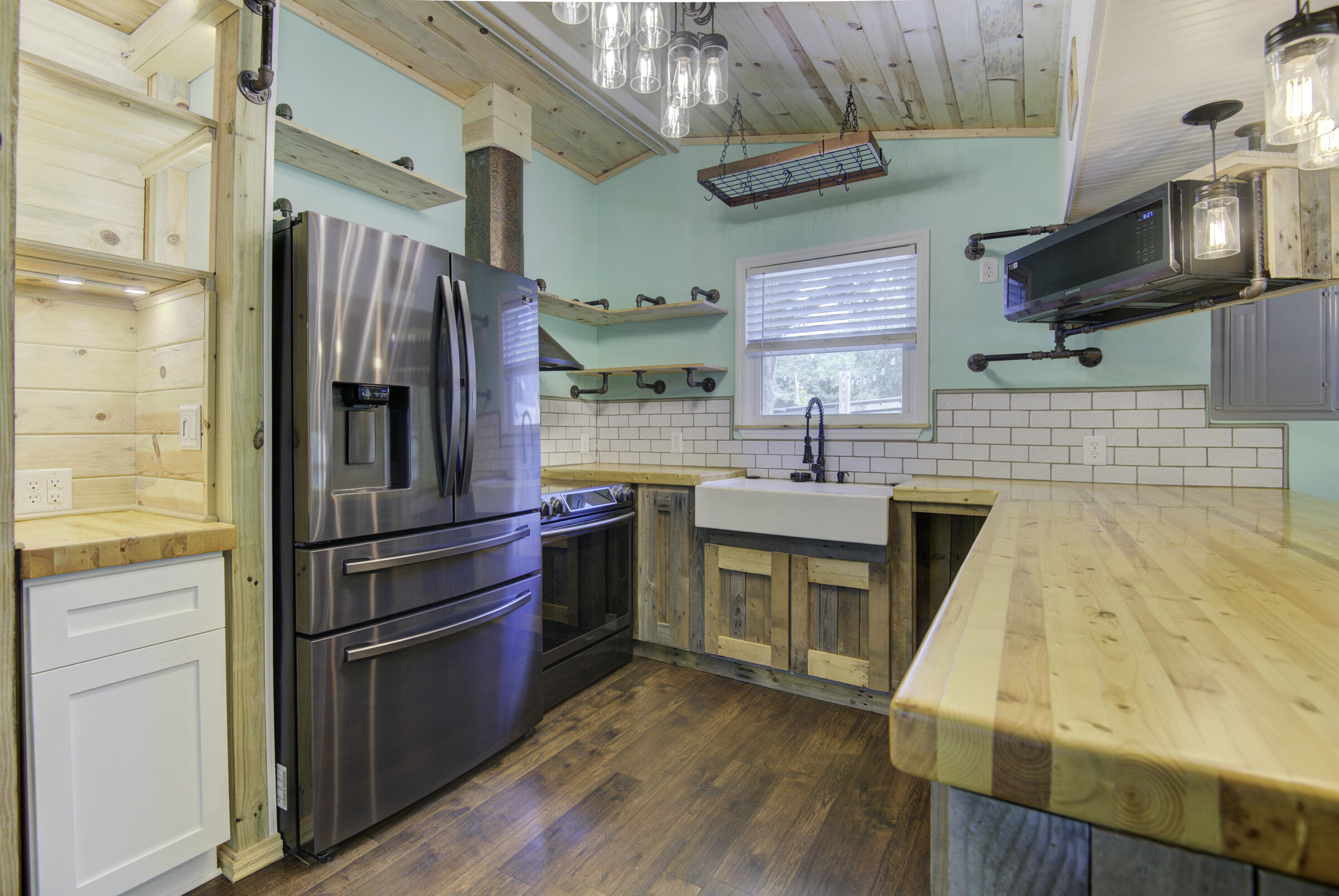 85 Our Street Vernon, FL 32462 - Photo 39 of 66 a kitchen with stainless steel appliances a sink cabinets and a wooden floor