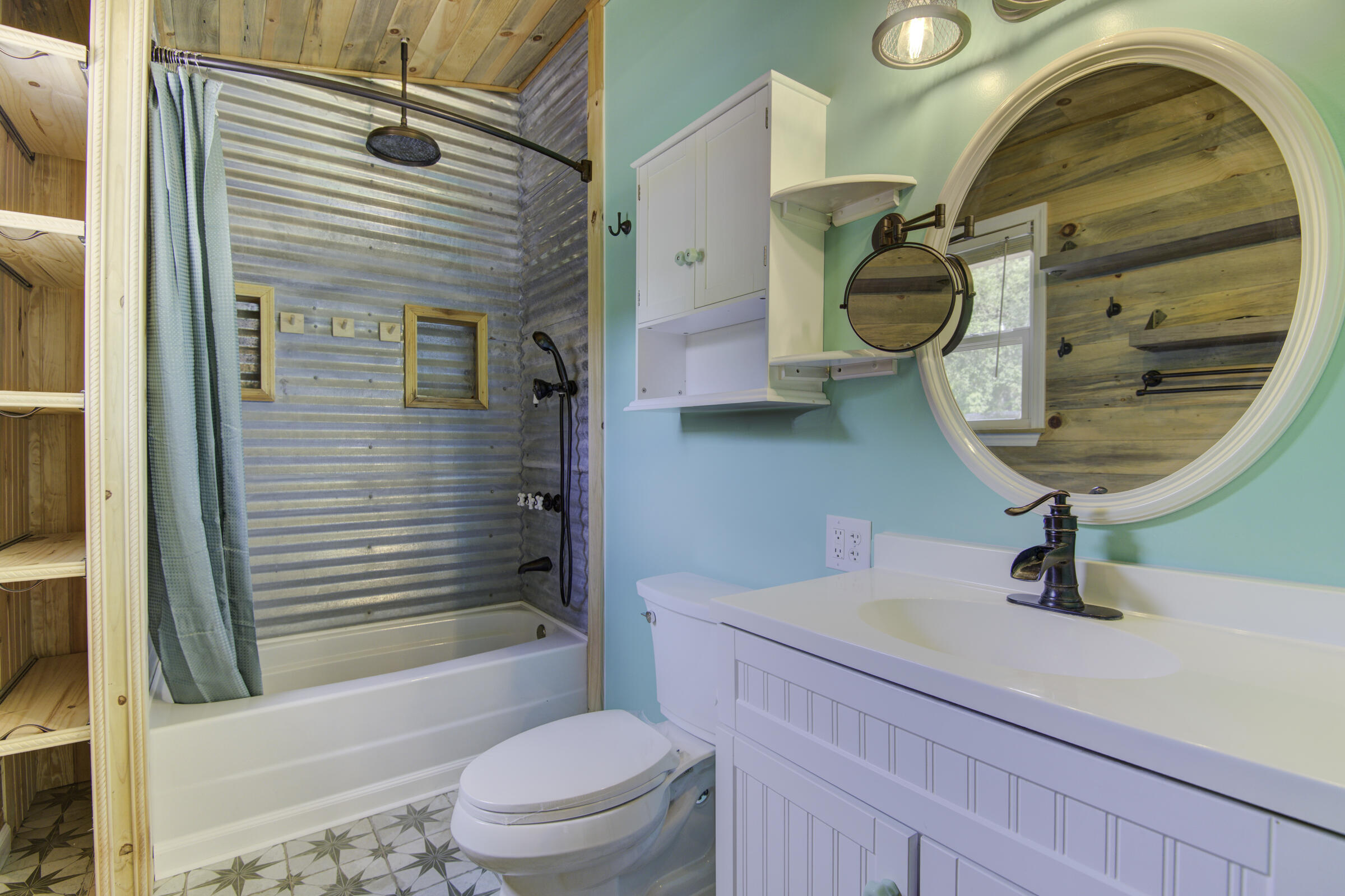 85 Our Street Vernon, FL 32462 - Photo 53 of 66 a bathroom with a sink a mirror a toilet and bathtub