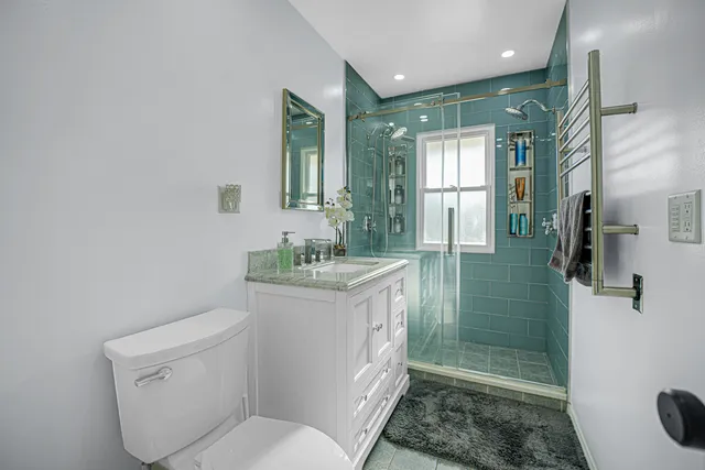 a bathroom with a granite countertop sink toilet and shower
