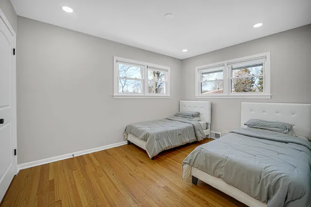 a bedroom with two beds and painting on the wall